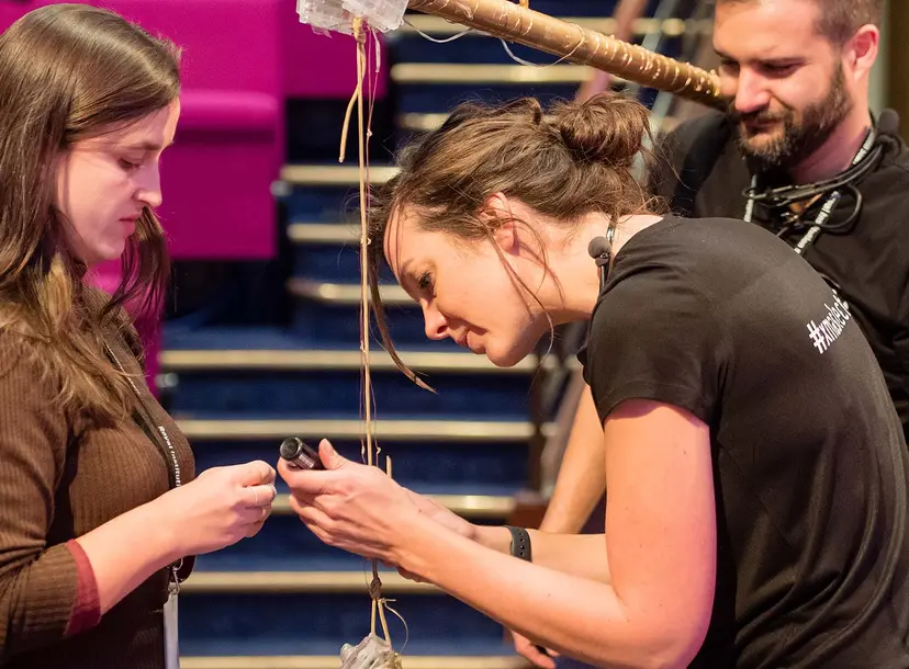three people working on a theatre prop