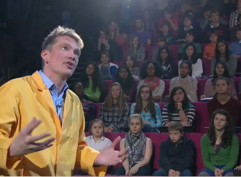 Peter Wother talking to a crowd of seated children during his CHRISTMAS LECTURE
