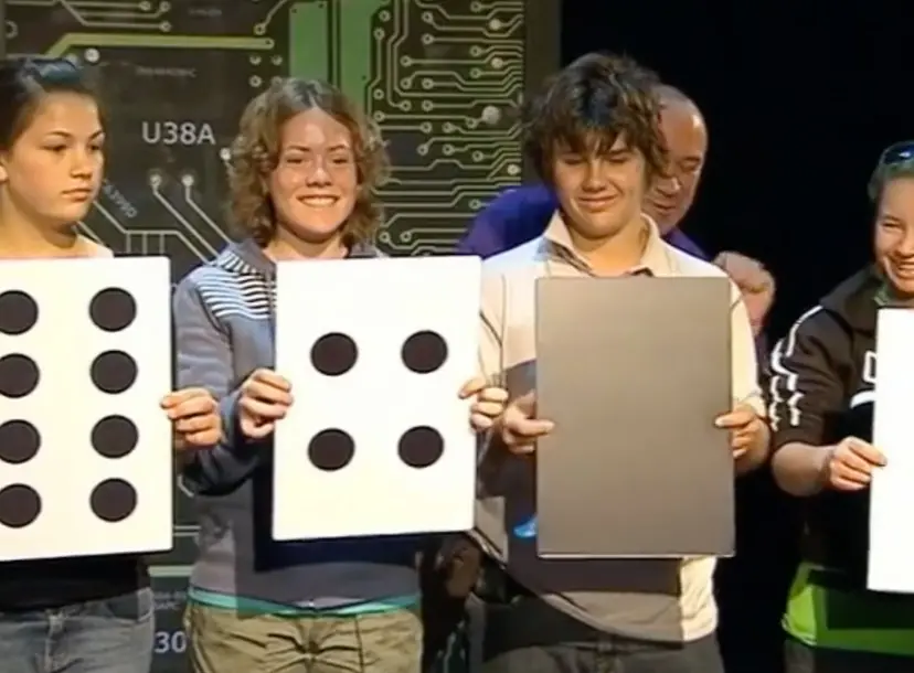 Four children holding up signs that have the pattern of dominoes