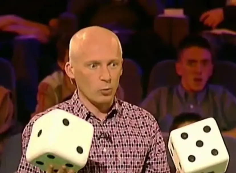 Marcus du Sautoy holding two large dice, standing in front of a crowd