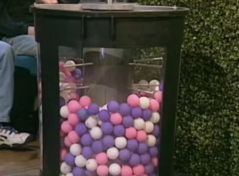 A clear cylinder filled with coloured balls