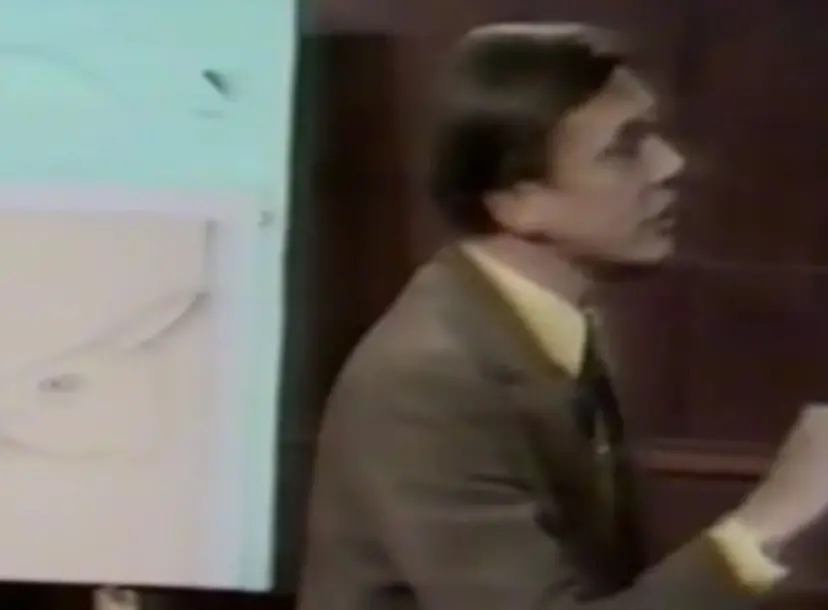David Attenborough speaking in the Ri theatre, in front of a sketch of a rabbit head