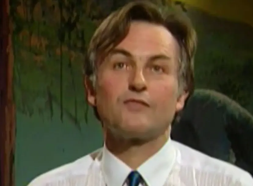 Richard Dawkins speaking in front of a dark green backdrop