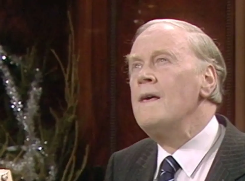 RV Jones speaking in the Ri Theatre, with a christmas tree in the background