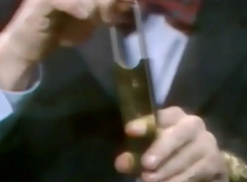 Heinz Wolff putting his finger in a contraption that looks like a cigar cutter
