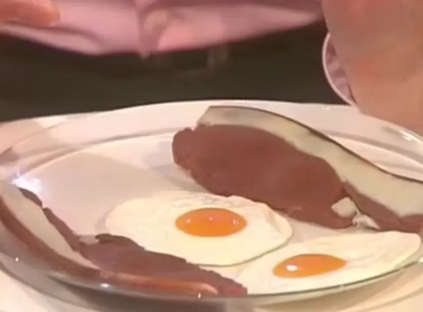 a plate of two fried eggs and two bacon rashers 