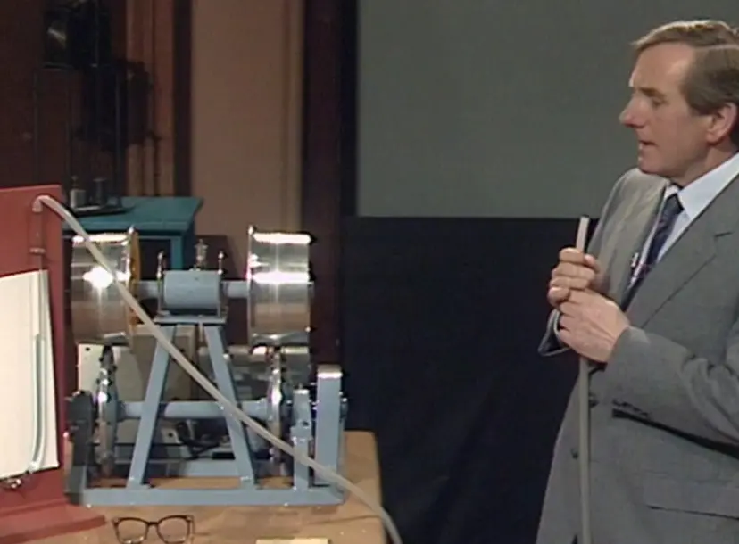 Leonard Maunder holding a rubber tube that is linked to two glass tubes