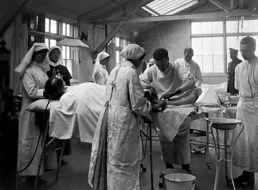 A black and white photo of surgeons and nurses around an operating table