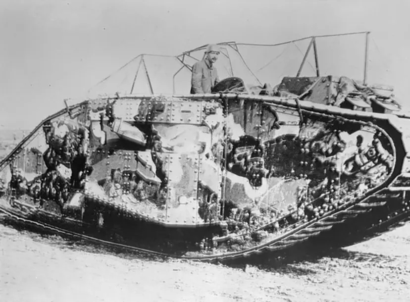 A black and white picture of a tank painted in camouflage pattern
