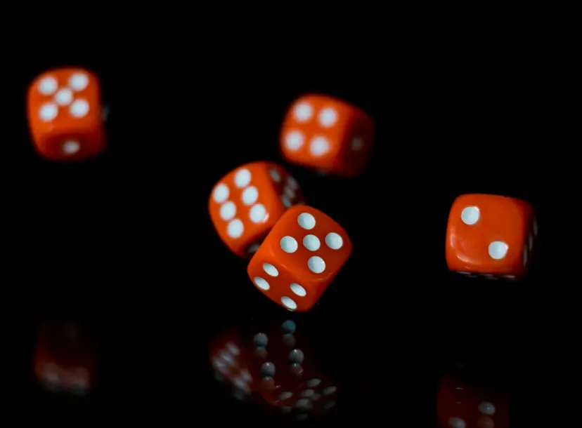 Five dices rolling on a dark background.