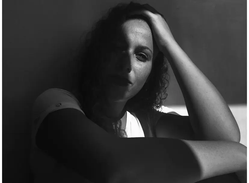 A women looks into the camera in a black and white image