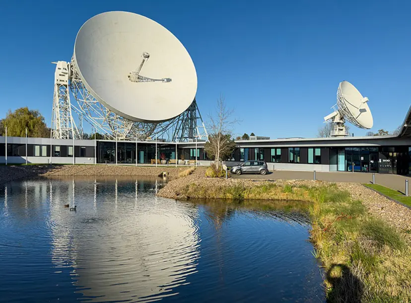 Parabolic dishes at Jodrell Bank, reflected in water