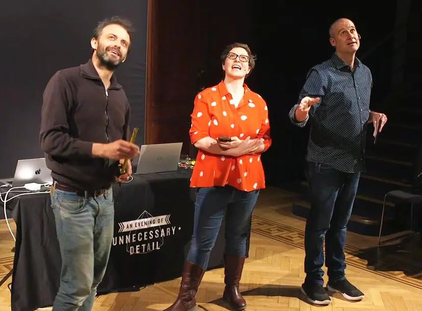 Three people standing in front of Faraday desk in Ri Theatre