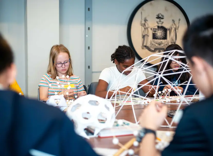 Participants sit building paper domes