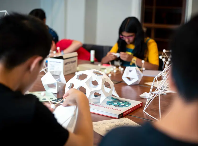 Participants sit building paper domes