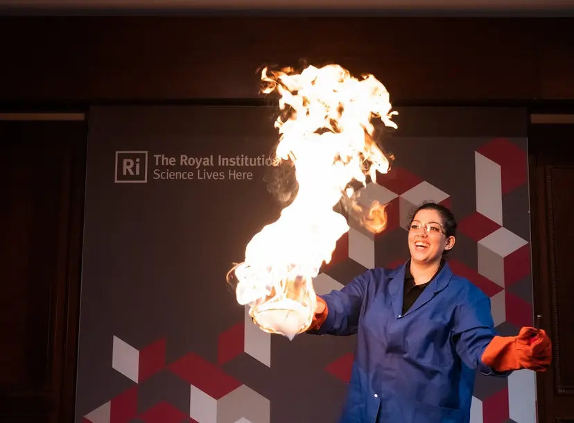 a woman is smiling as bubbles are set on fire
