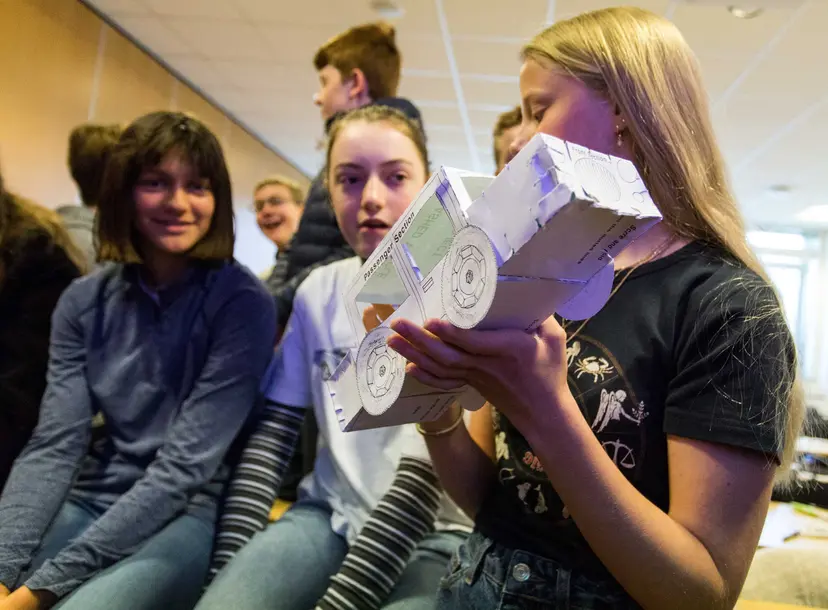 Participants holding a crash test model at a workshop