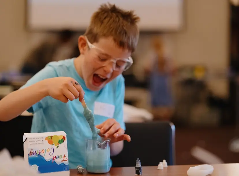 a young boy is playing with blue slime
