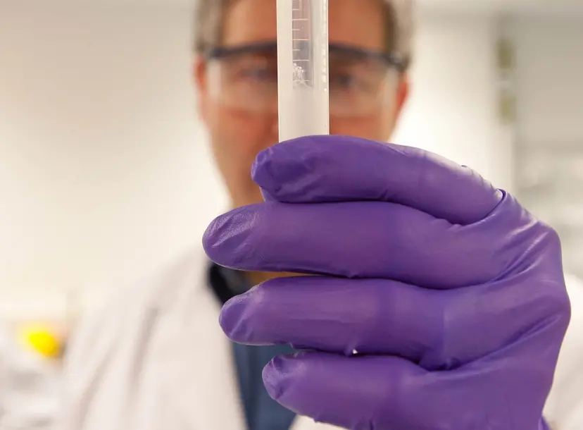 Person looking at tube filled with DNA