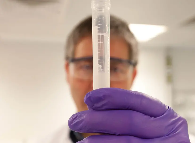 A person holds a tube filled with DNA