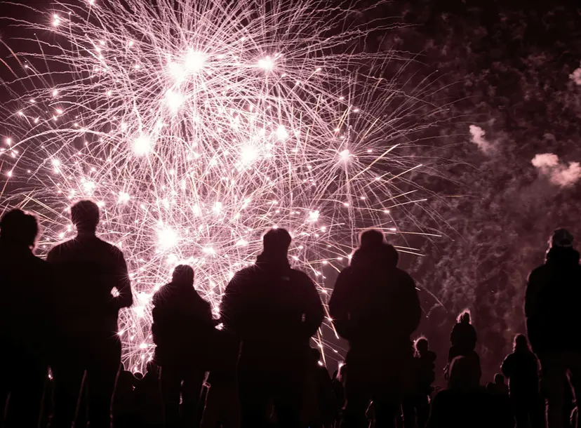 silhouettes of people watching a fireworks display