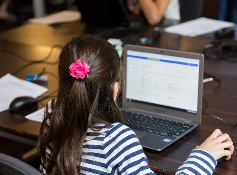 Child sat working on a laptop
