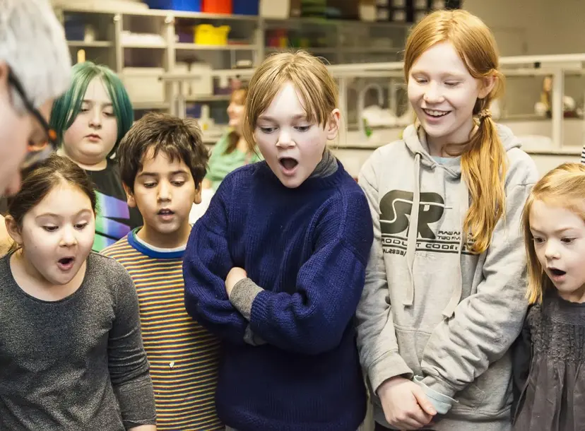 Children looking at something in awe in a computer science workshop