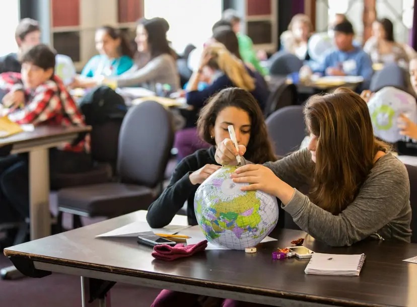 Children in a classroom with plastic globes