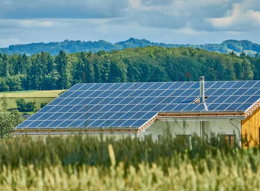 A house in the countryside with a roof filled with solar panels