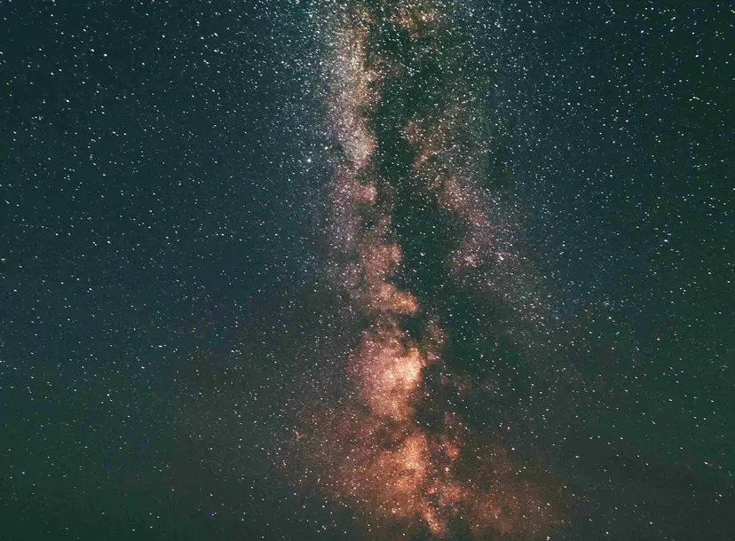 The silhouette of three people looking up at the stars