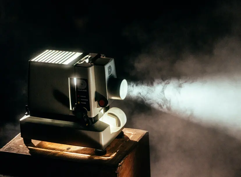 a black projector is on and a light is shining out of the front of it