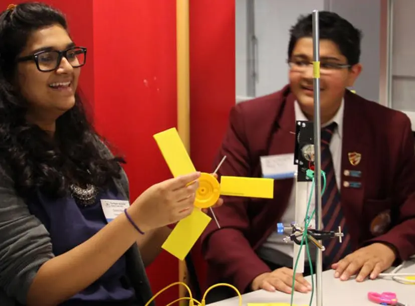 An adult and student experimenting with a fan