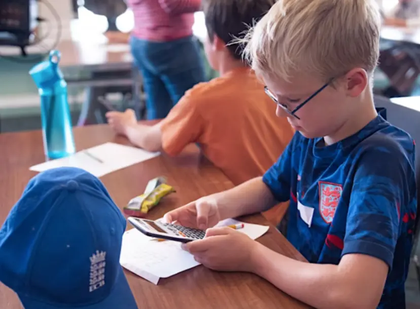 Blonde boy using a calculator