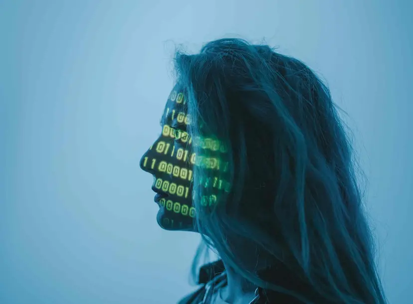A women stands in front of projection of codes