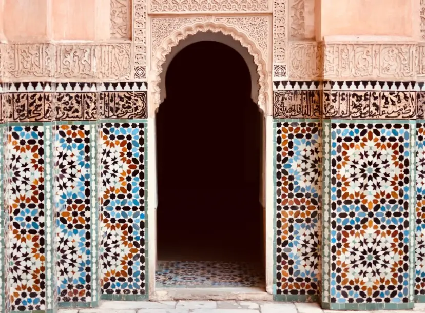A arch shaped doorway surrounded by coloured tiles. 