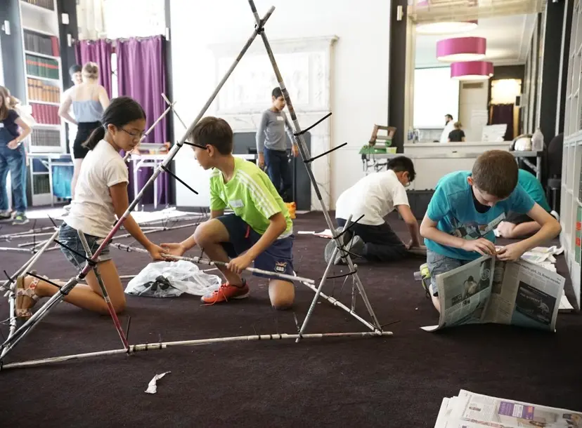 Students building structures with newspaper solid cane