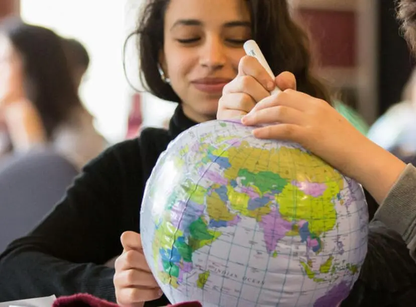 a student is looking at a globe