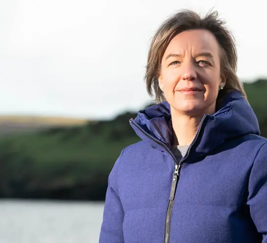 2020 Christmas Lecturer Tara Shine in a puffer jacket on a beach