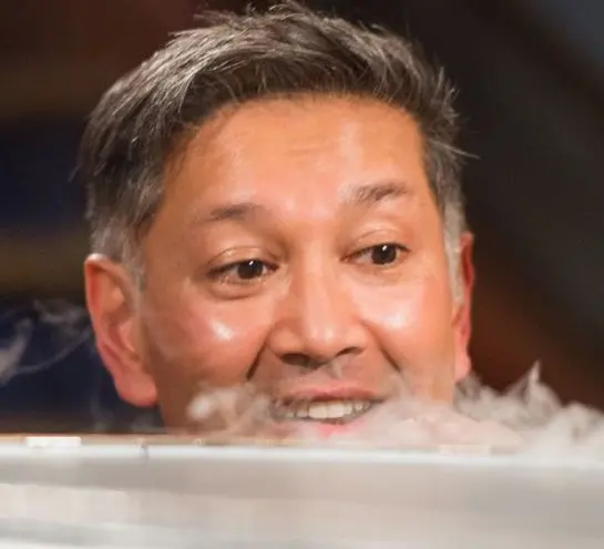 Saiful Islam looking over a cannister which gas is pouring out of