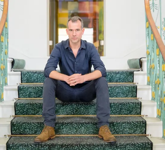 Chris Van Tulleken sitting on the grand staircase in the Royal Institution