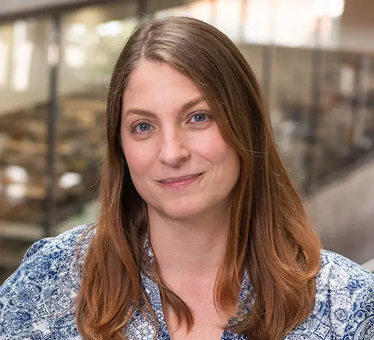 woman with long brown hair and a blue white patterned top