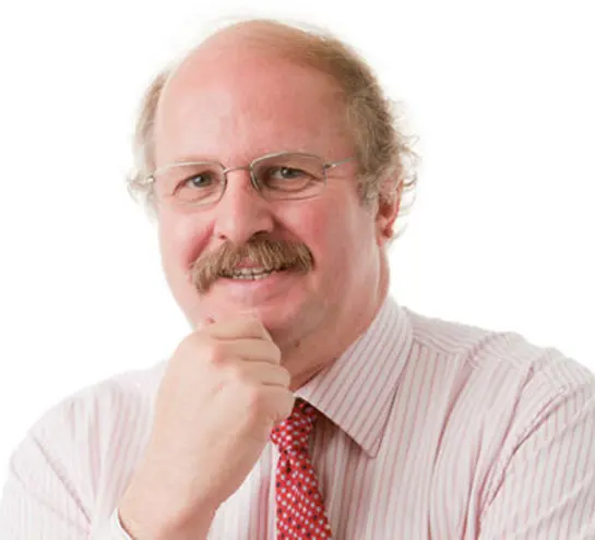 Frank James, smiling with a hand on his chin