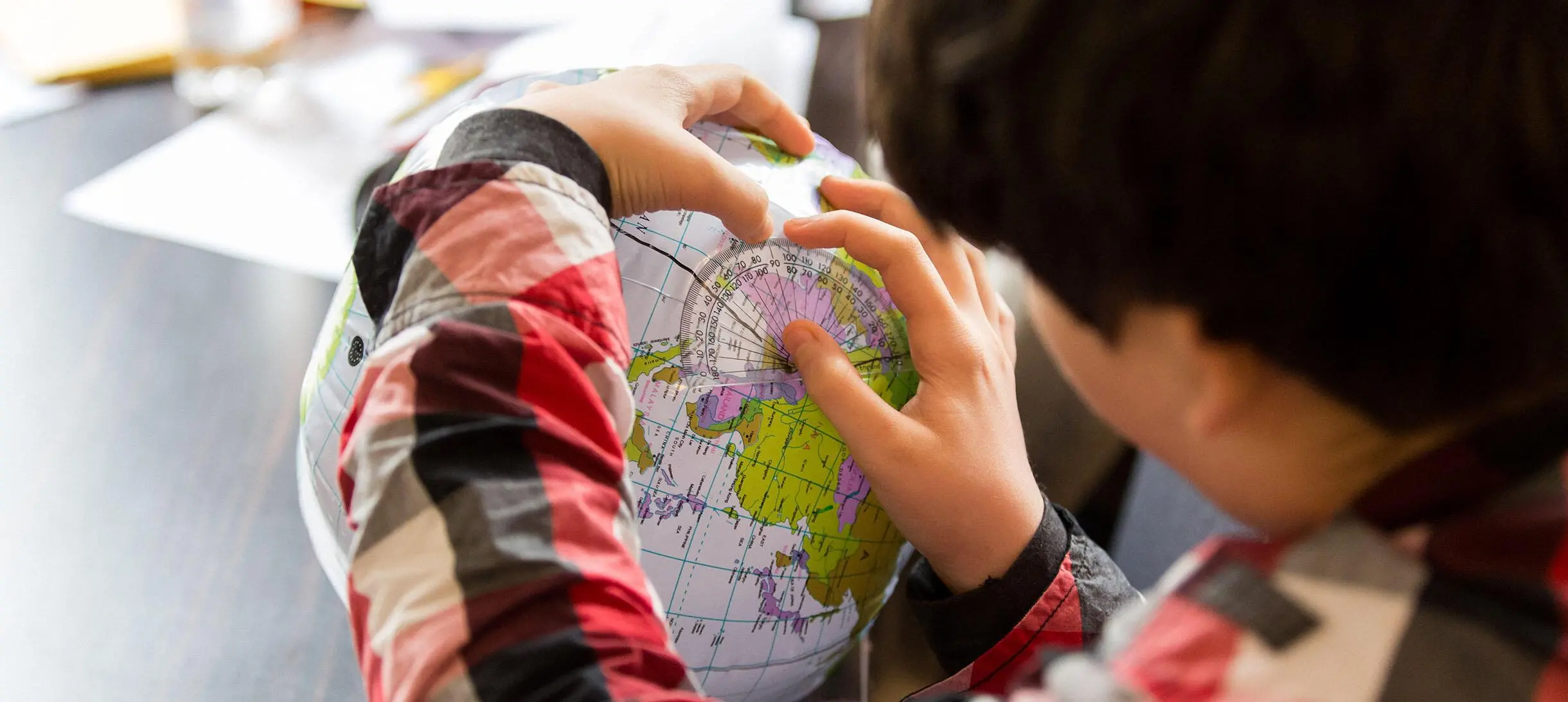 A boy looks at a globe