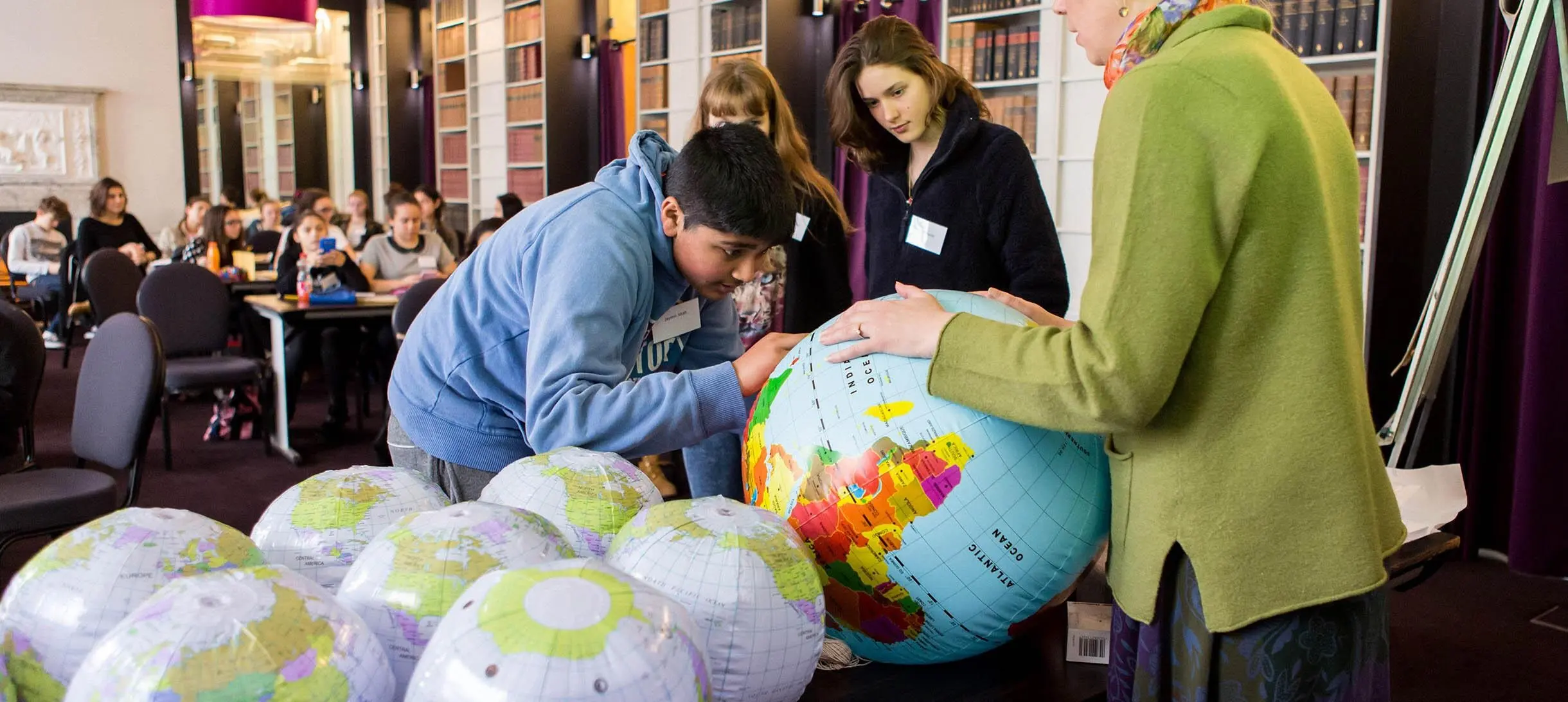 Students interacting with an inflatable globe during a maths Masterclass in the Ri's Conversation Room
