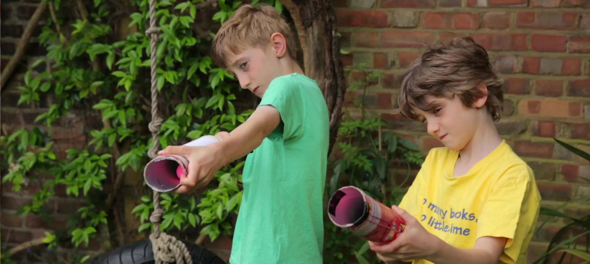 two boys holding up Pringles cans as if they are cannons