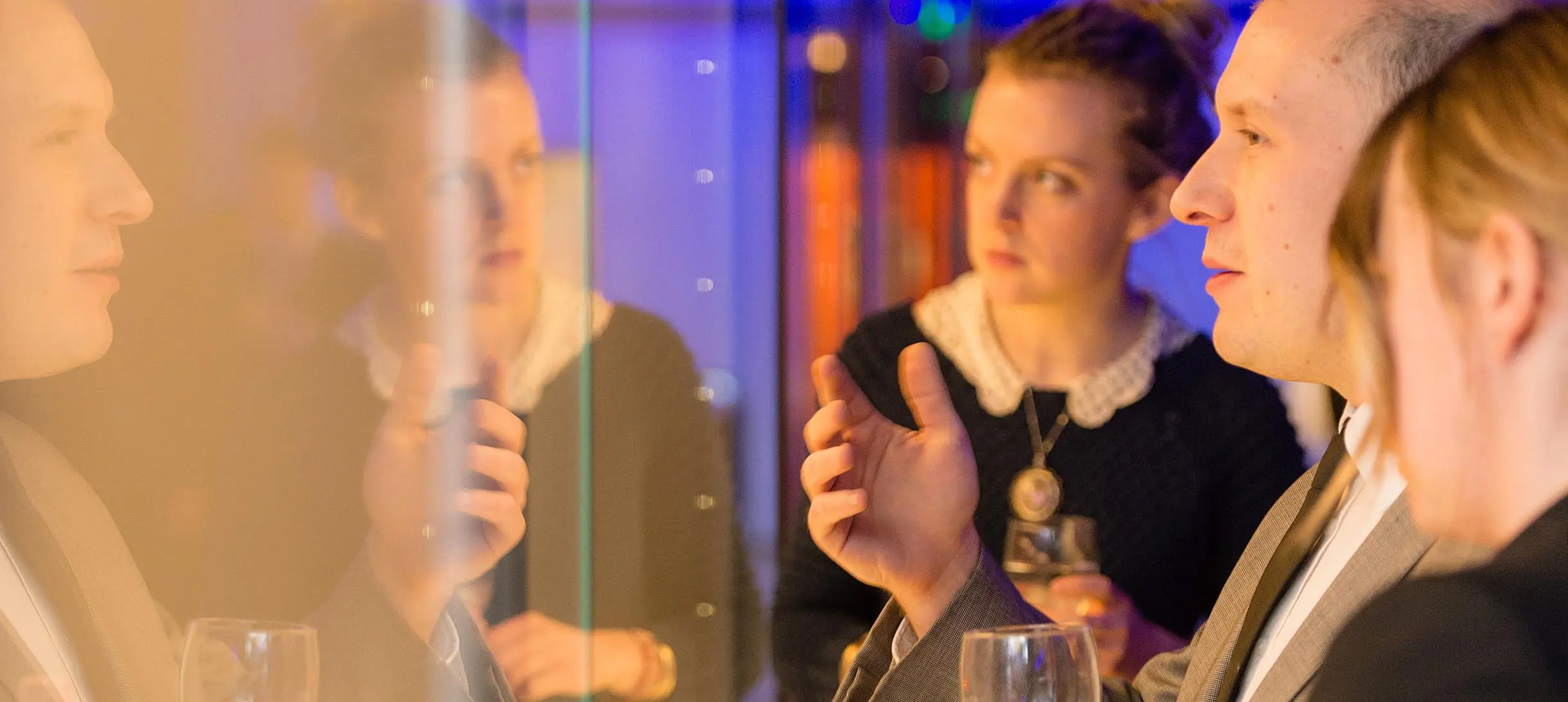 three people looking at something through a display cabinet