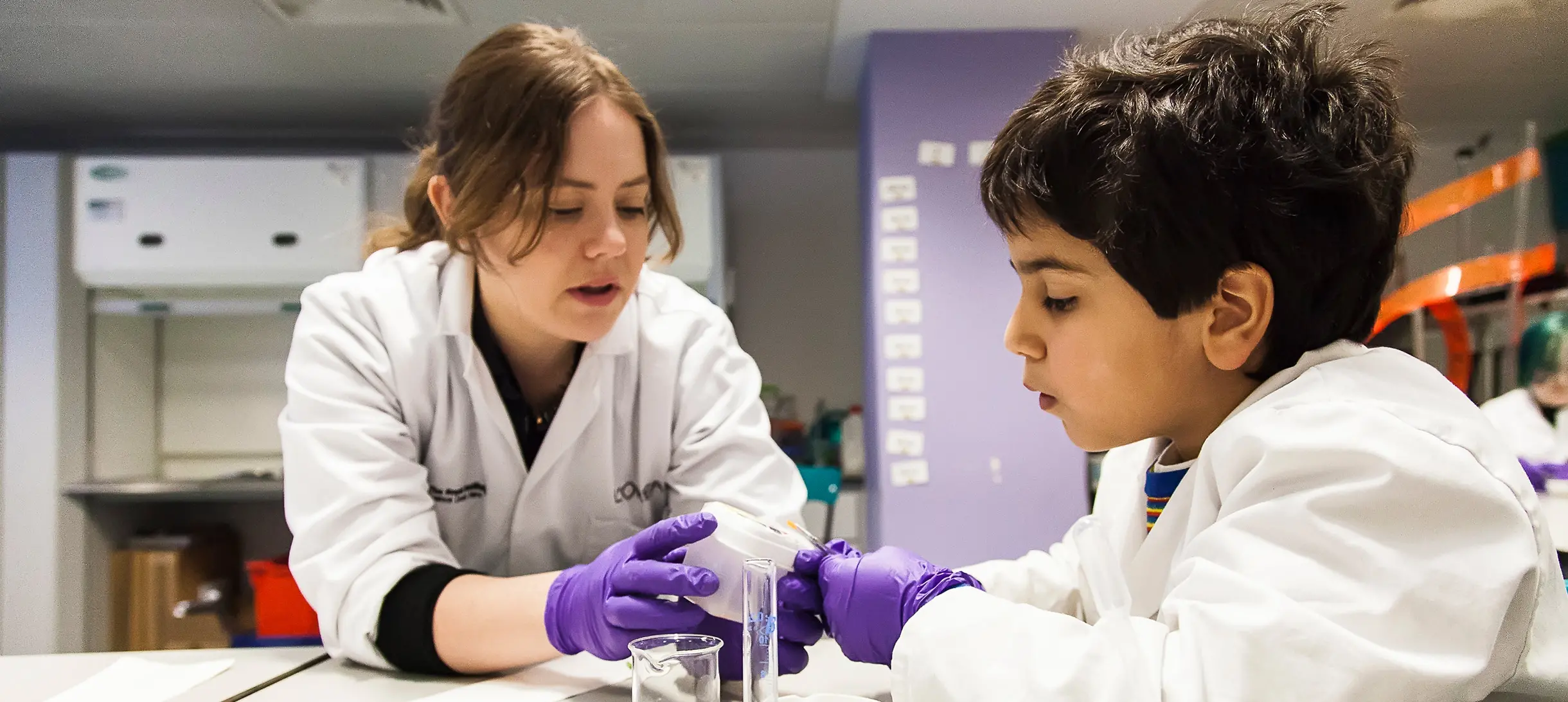 One of staff engaging with a child in the lab