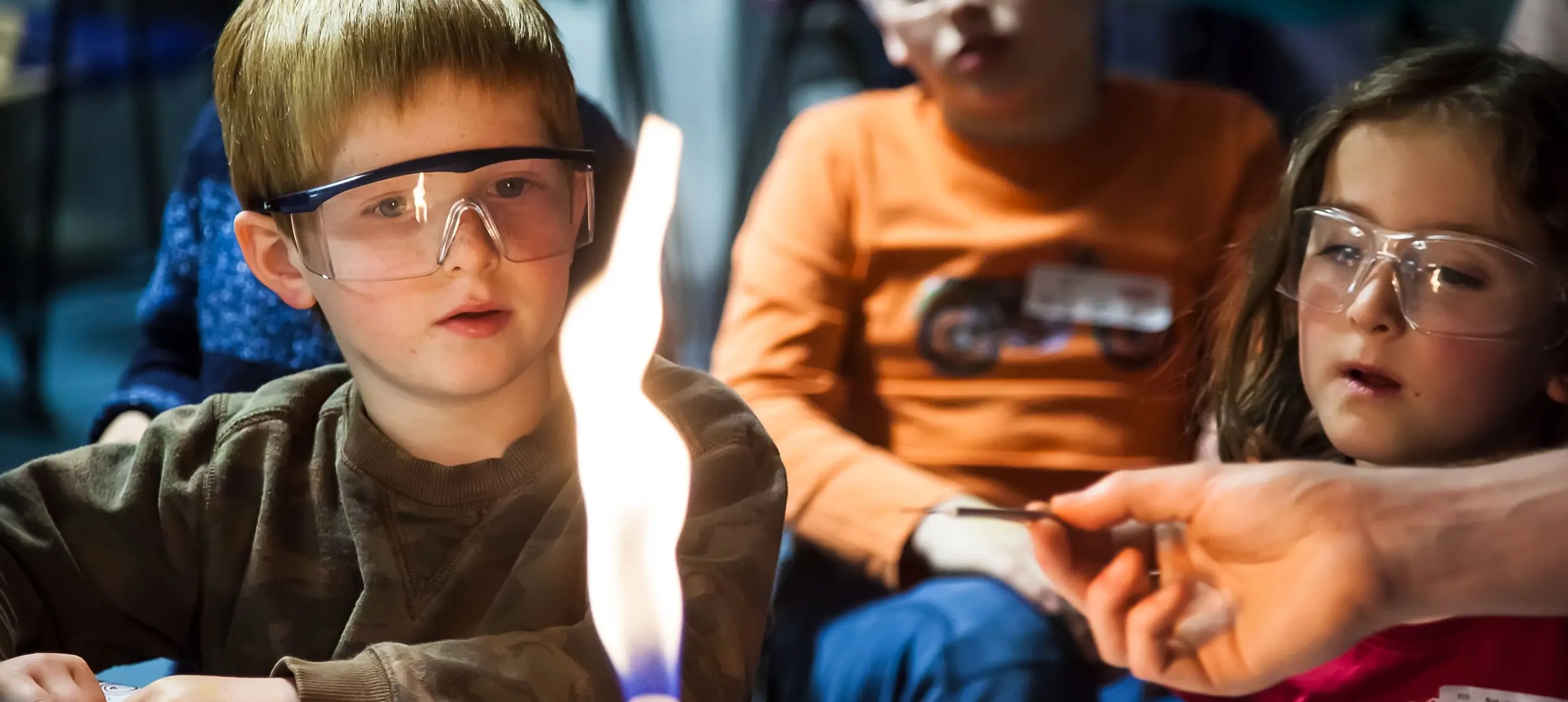 Children looking at a flame during a family fun day