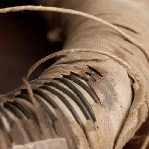 closeup of an iron ring covered in copper wires and cotton cloth