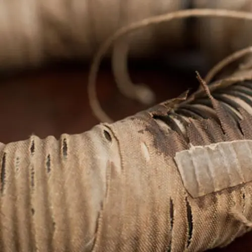 closeup of an iron ring covered in copper wires and cotton cloth